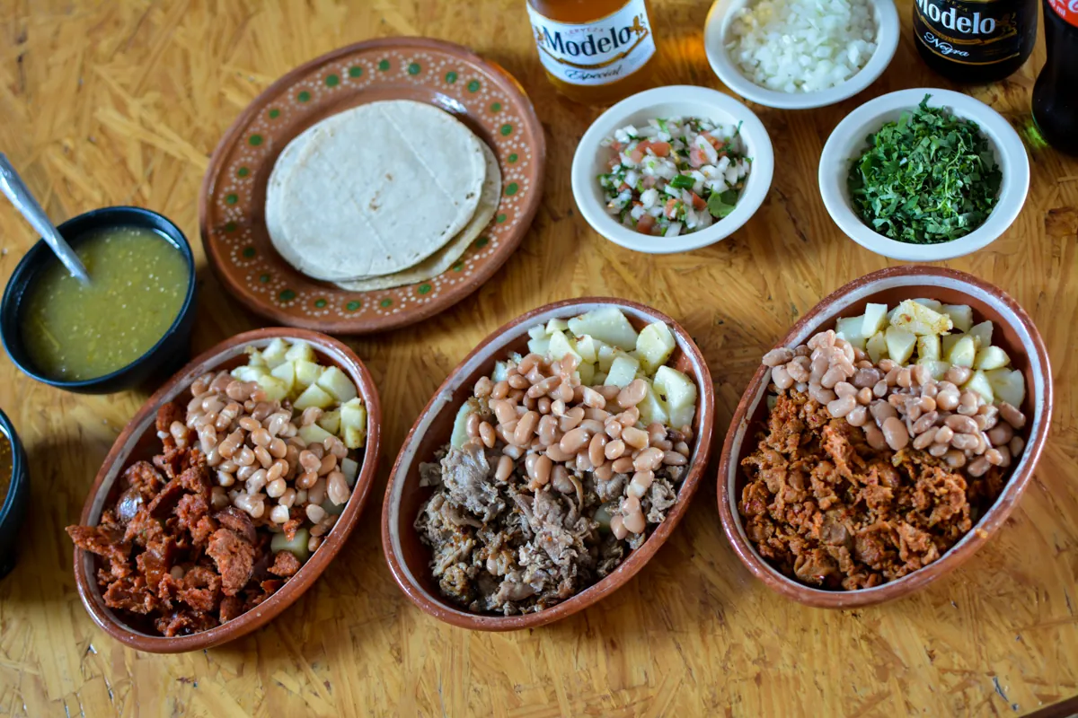 Órdenes con papas de chorizo, bistec y adobada con frijoles, salsa verde, pico de gallo y tortillas