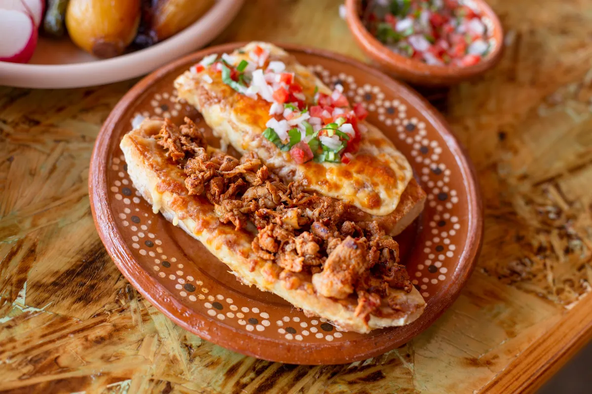 Molletes gratinados con adobada y pico de gallo